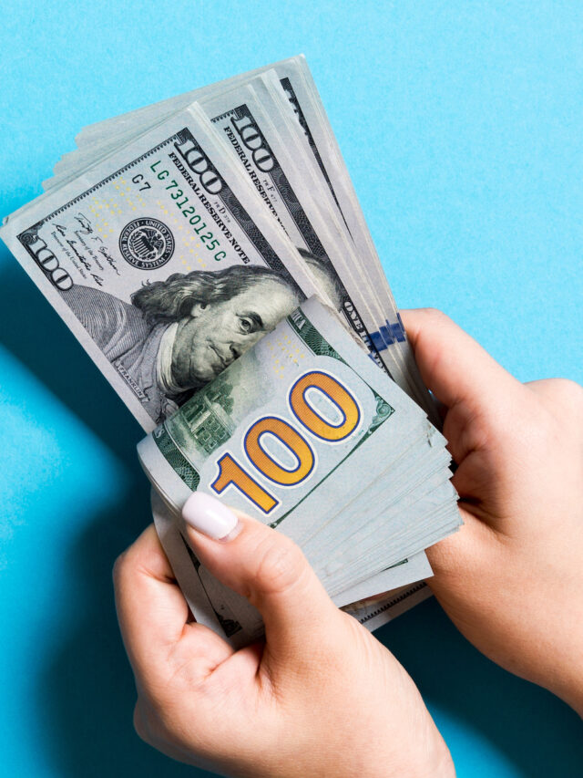 Top view of a businesswoman's hands counting one hundred dollar banknotes on colorful background. Success and wealth concept with copy space