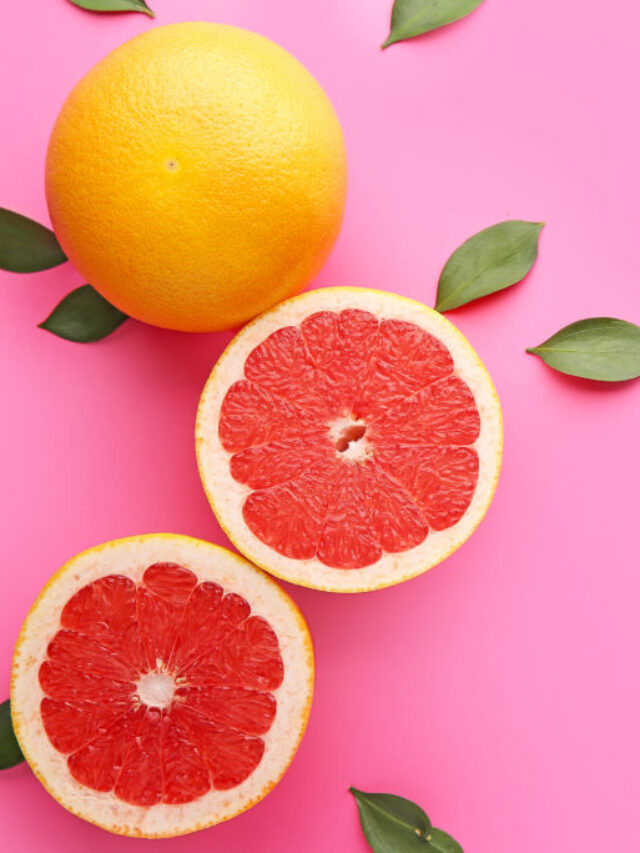 Fresh grapefruits on color background